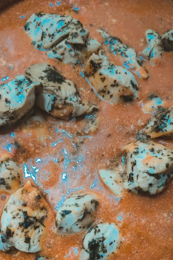 returning cooked chicken chunks to pan