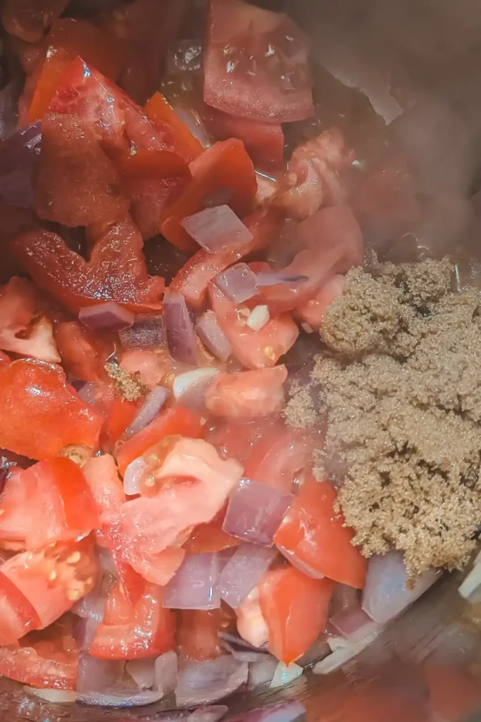 adding brown sugar to tomato and onion