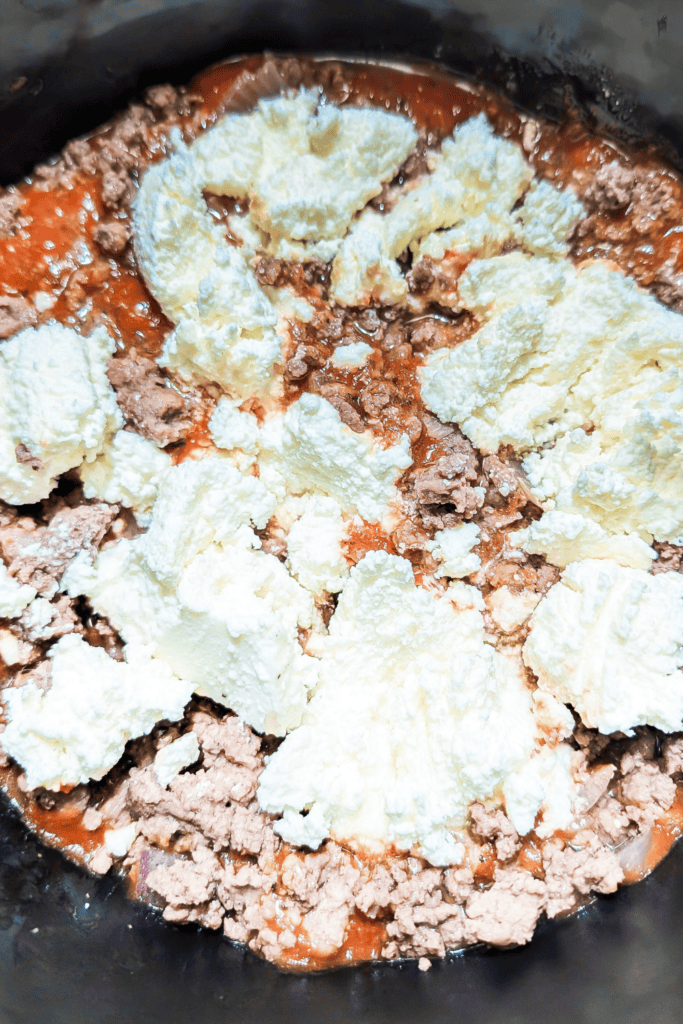 adding ricotta cheese to the dutch oven