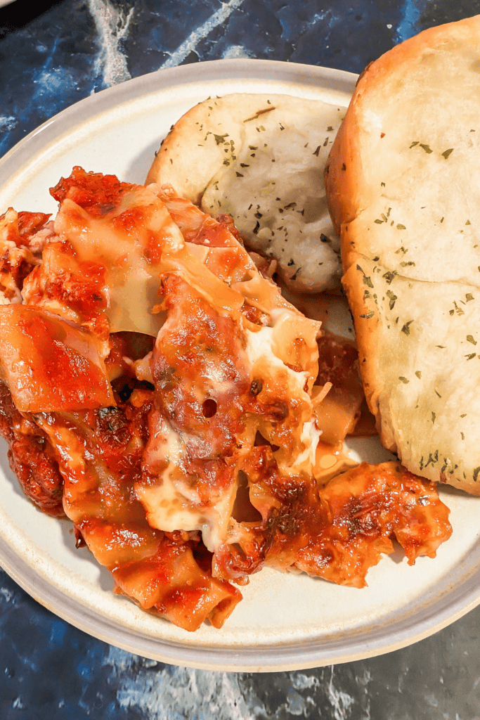 from above lasagna on plate with garlic bread