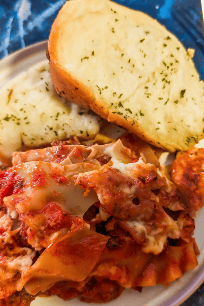 lasagna on plate with pull apart garlic bread