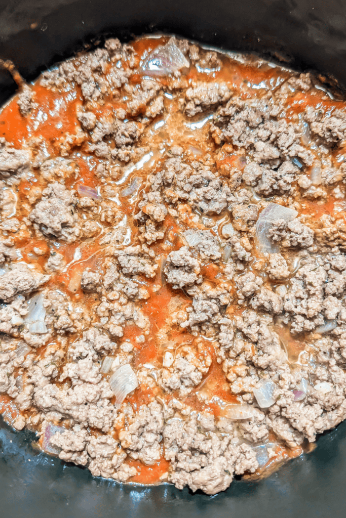 layering tomato meat sauce in bottom of dutch oven