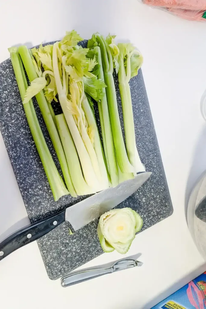 cutting the end off of celery stalks on cutting board