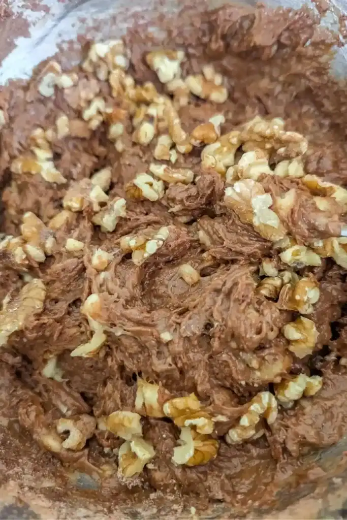 adding walnuts to chocolate banana muffin batter