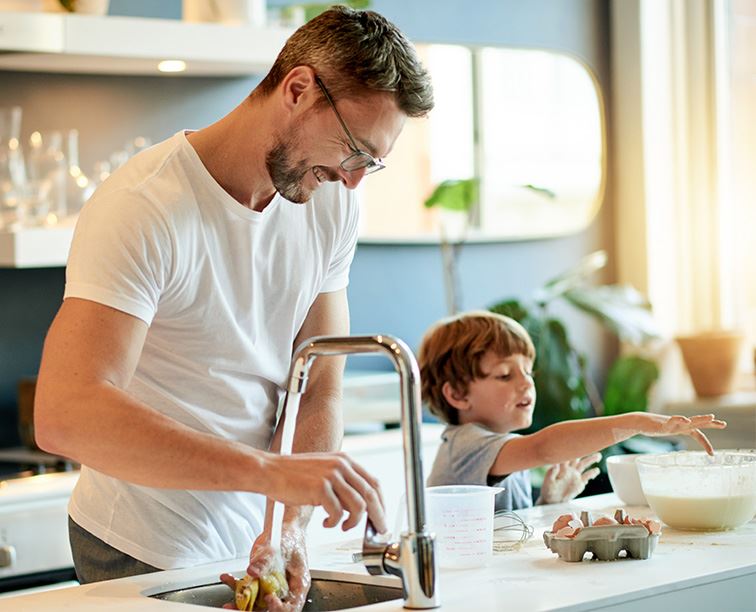 A family cooks together in a kitchen, feeling confident with help from Cirigliano Plumbing LLC.