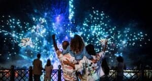 A family stands watching Luminous a Symphony of us at Epcot