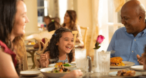 Family Sitting Down to a Table Service Meal