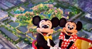 Mickey and Minnie on ride with background of new Disneyland theme park