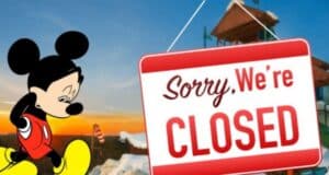 Mickey Mouse looking sad in front of a "closed" sign on an image of Blizzard Beach