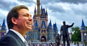 Governor DeSantis smiling broadly with an image of cinderella's castle at walt disney world.