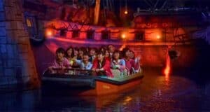 Guests riding a Pirates of the Caribbean boat at Tokyo Disneyland.