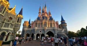 Guests walking in Fantasyland at Magic Kingdom behind Cinderella Castle