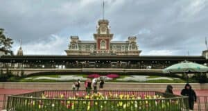 The Walt Disney World Railroad boarding station near the entrance of Magic Kingdom on Main Street, U.S.A., during a cloudy day with guests and security cast members.