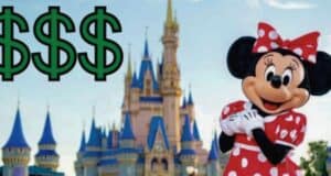A person dressed as Minnie Mouse, a character in a red polka dot dress, stands in front of a castle with blue spires. Three large green dollar signs ($$$) are prominently displayed to the left. The sky is clear and blue.