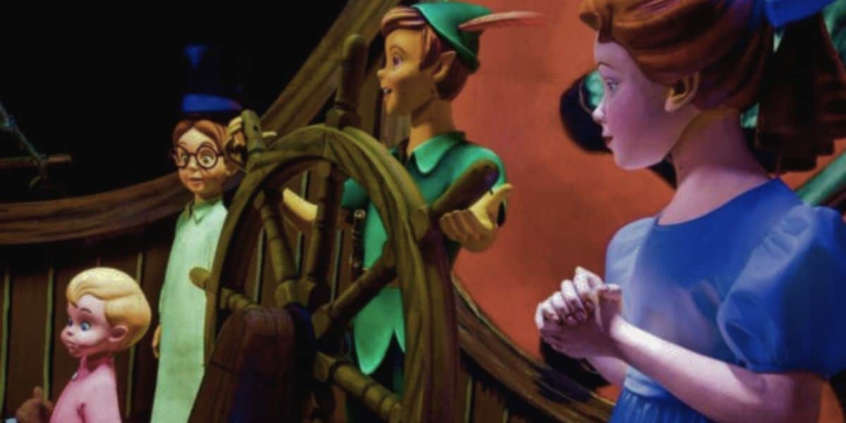 A group of animated characters is shown on a ship. A boy wearing green clothes and a hat with a feather stands at the ship's wheel. To his left is a girl in a blue dress. Both are standing with two other children, one in pink pajamas and another with glasses, reminiscent of a magical day at Disney World.