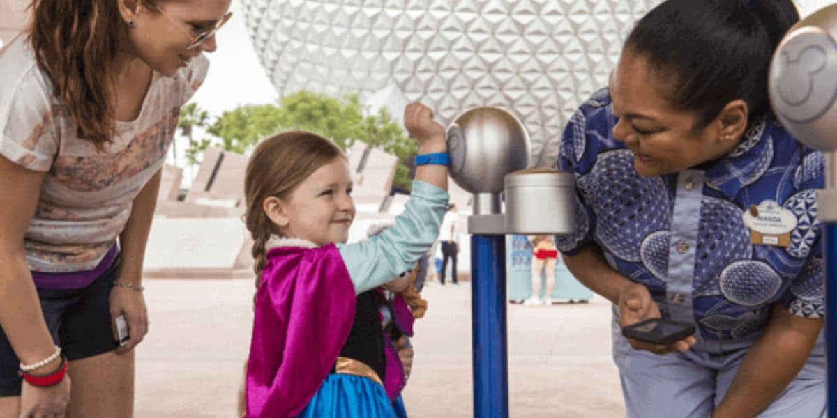 A little girl scanning her MagicBand and fingerprint to enter EPCOT at Walt Disney World Resort.