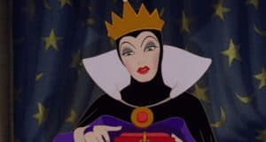 An illustrated queen, reminiscent of Disney's scariest villains, in a dark outfit and gold crown gazes down at a small red box in her hands. The backdrop is a curtain adorned with stars.