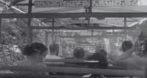 Black and white photo of people sitting inside a Kilimanjaro Safaris ride vehicle.