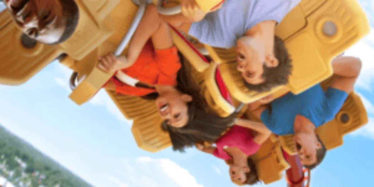 A group of people are riding the Hollywood Rip Ride Rockit roller coaster, hanging upside down.