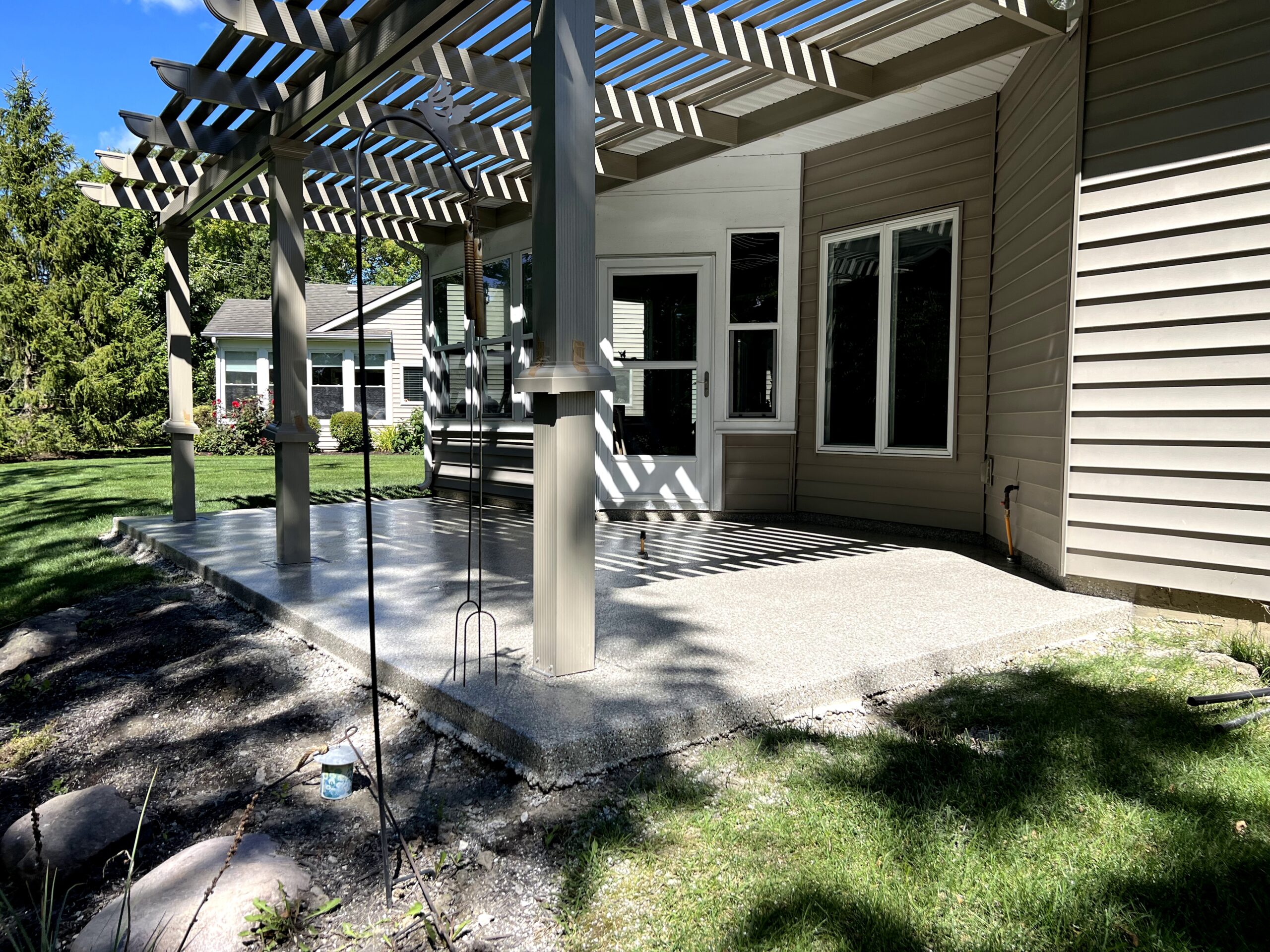 A backyard patio shows durable, clean flooring by Duration Concrete Coatings by Duralast, creating a welcoming outdoor space.