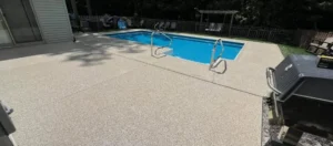 A backyard shows a safe, inviting pool area with textured patio flooring by Duration Concrete Coatings by Duralast.