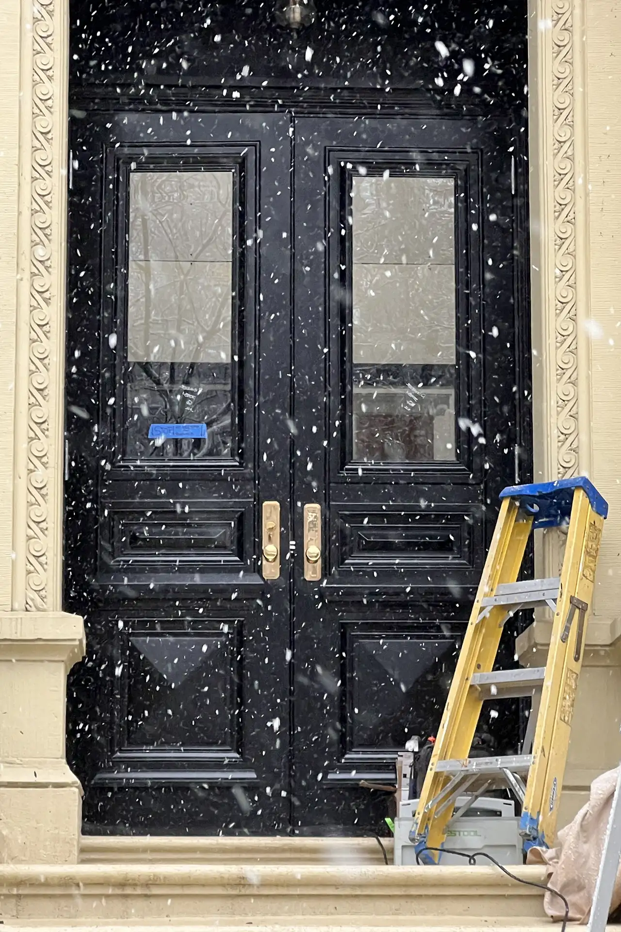 Residential Door Installation Service in Boston. Light snow falls as installation is finished on a new door in a Boston neighborhood.