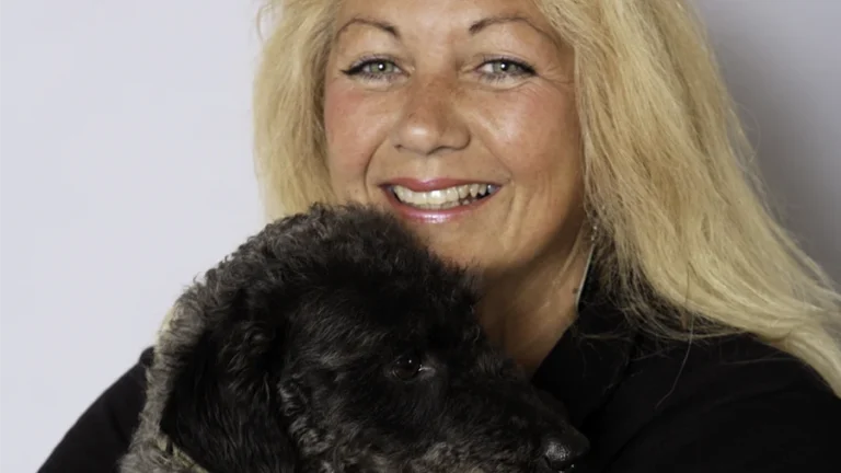 Photo of a pretty woman holding a small black dog