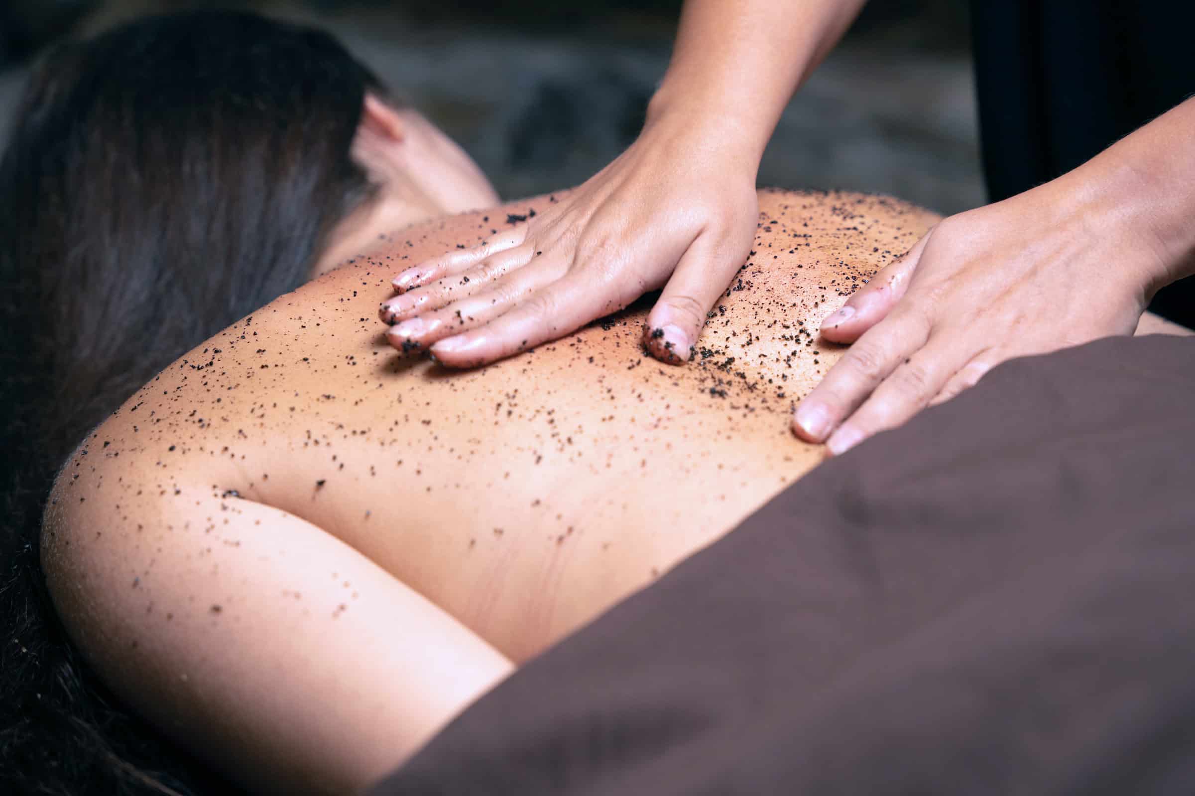 A woman receiving a coffee scrub