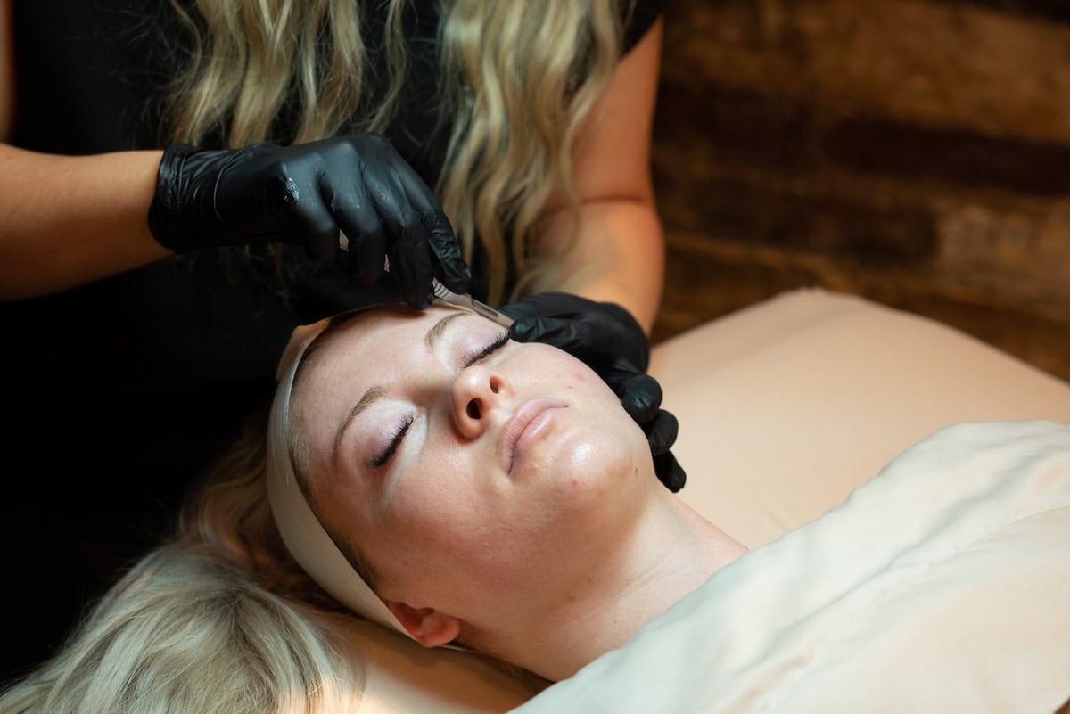 A client receiving a dermaplaning treatment