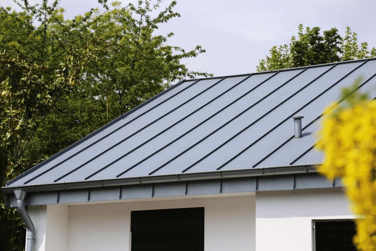 A Hillside Metal roof makes this modern house look durable and stylish, with trees adding to the inviting feel.