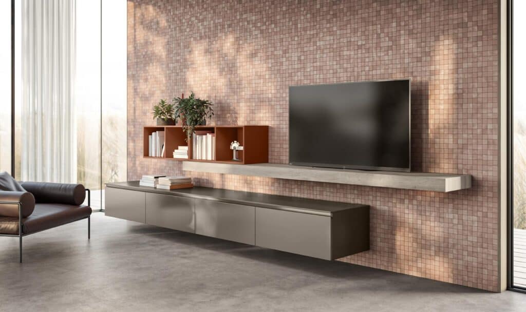 Modern living room with a wall-mounted TV, floating shelves with books and plants, and a dark sofa.