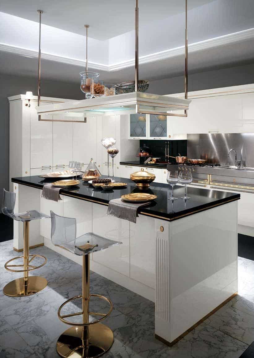 Modern kitchen with white cabinetry, a black countertop, gold accents, transparent bar stools, and elegant decor.