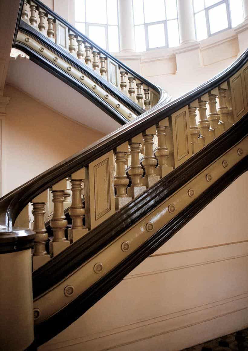 Ornate wooden staircase with decorative balusters and handrails.