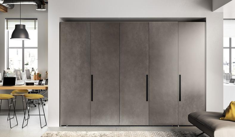 Modern gray wardrobe with black handles in a contemporary room.