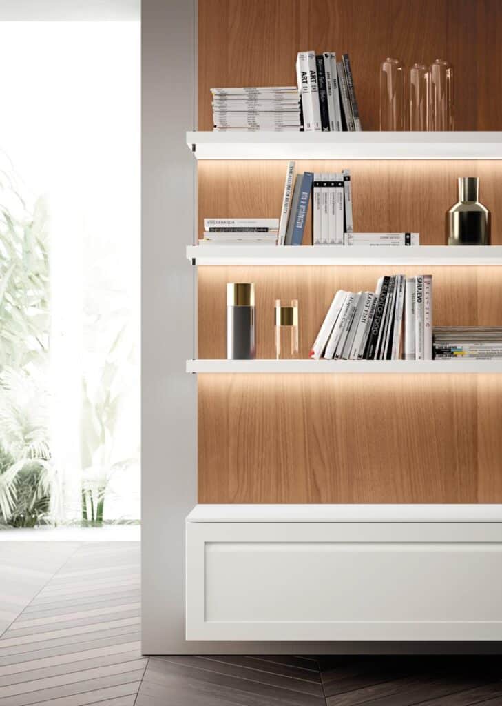 Modern wooden bookshelf with white shelves, books, decorative vases, and soft lighting.