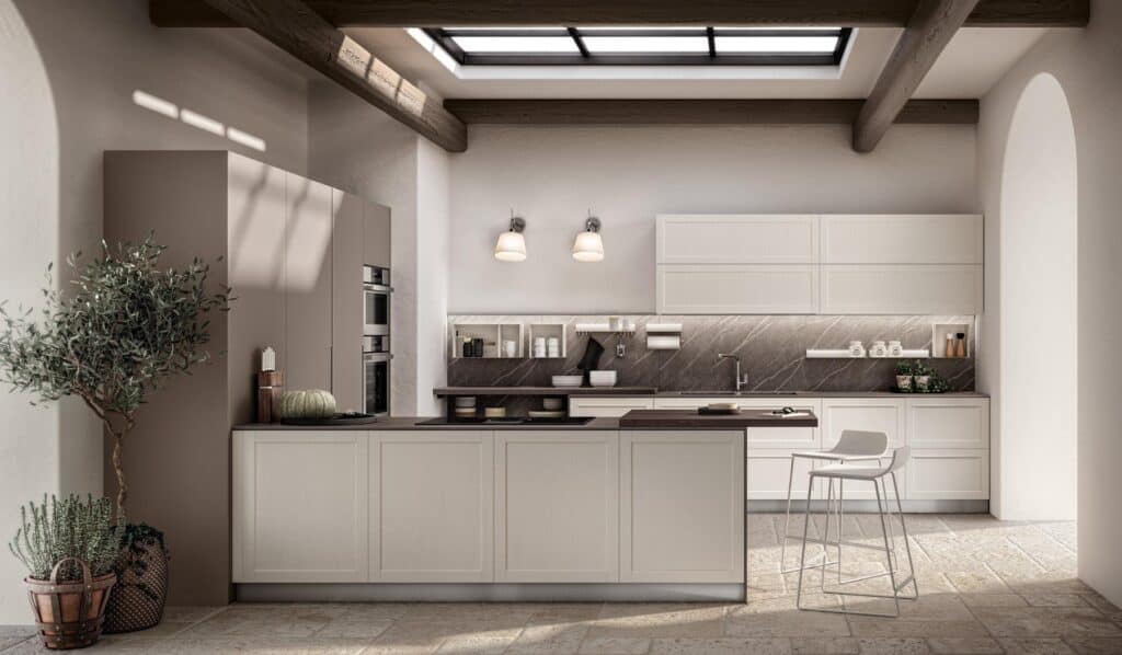 Modern kitchen interior with beige cabinets, an island with bar stools, skylight, and potted plants.