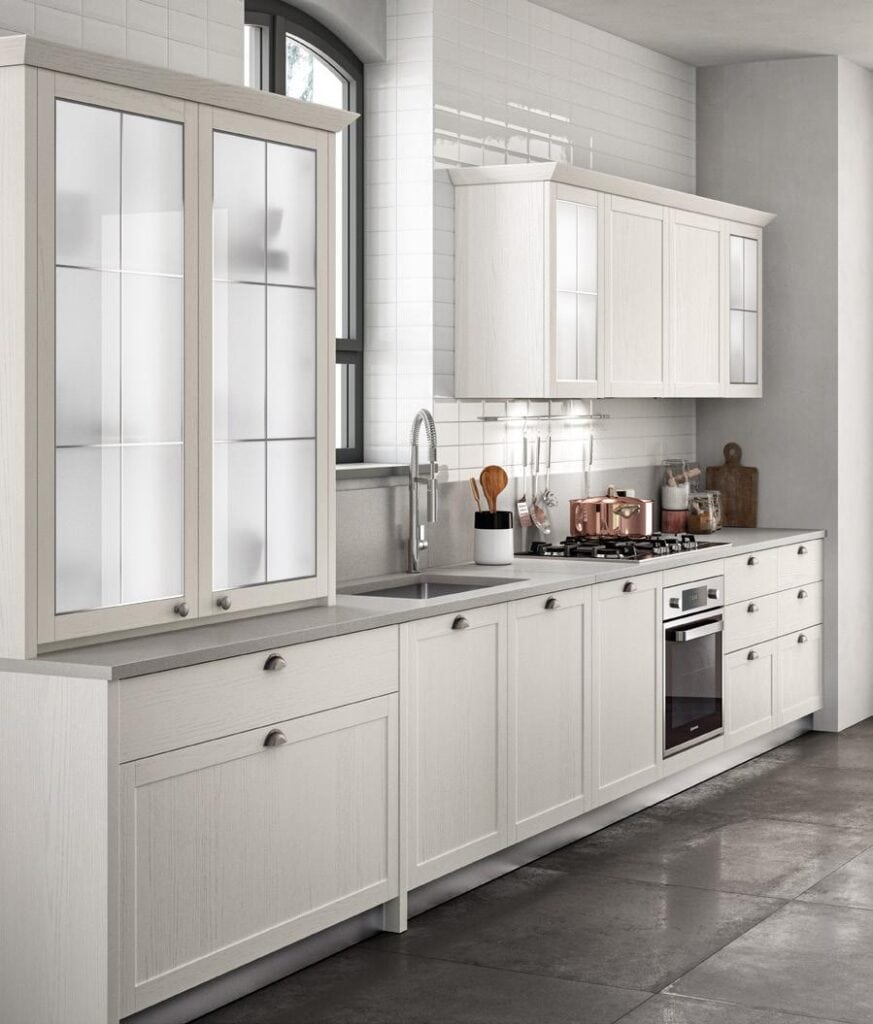 Modern kitchen with light-colored cabinets, a built-in oven, a stovetop, and a large sink.