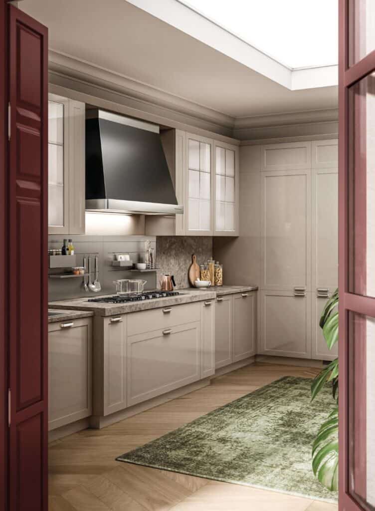 Modern kitchen with beige cabinetry, stainless steel appliances, a granite countertop, and a green rug on a light wood floor.