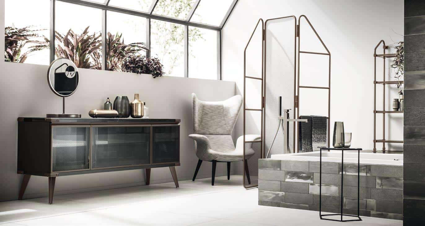 Modern bathroom with a large armchair, glass-front cabinet, decorative objects, and a bathtub with metal fixtures.