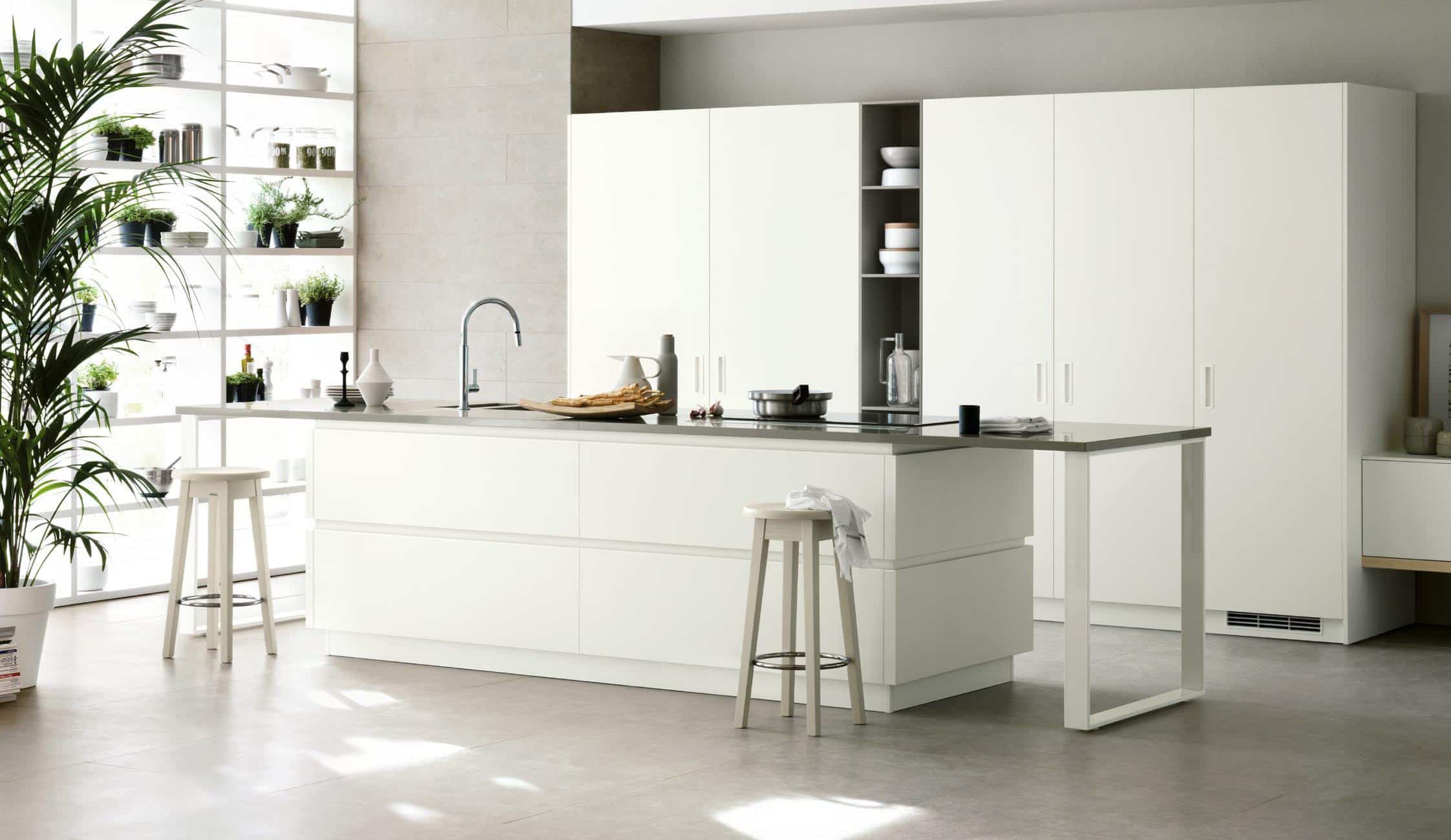 Modern kitchen with white cabinets, island, bar stools, and open shelving with plants.