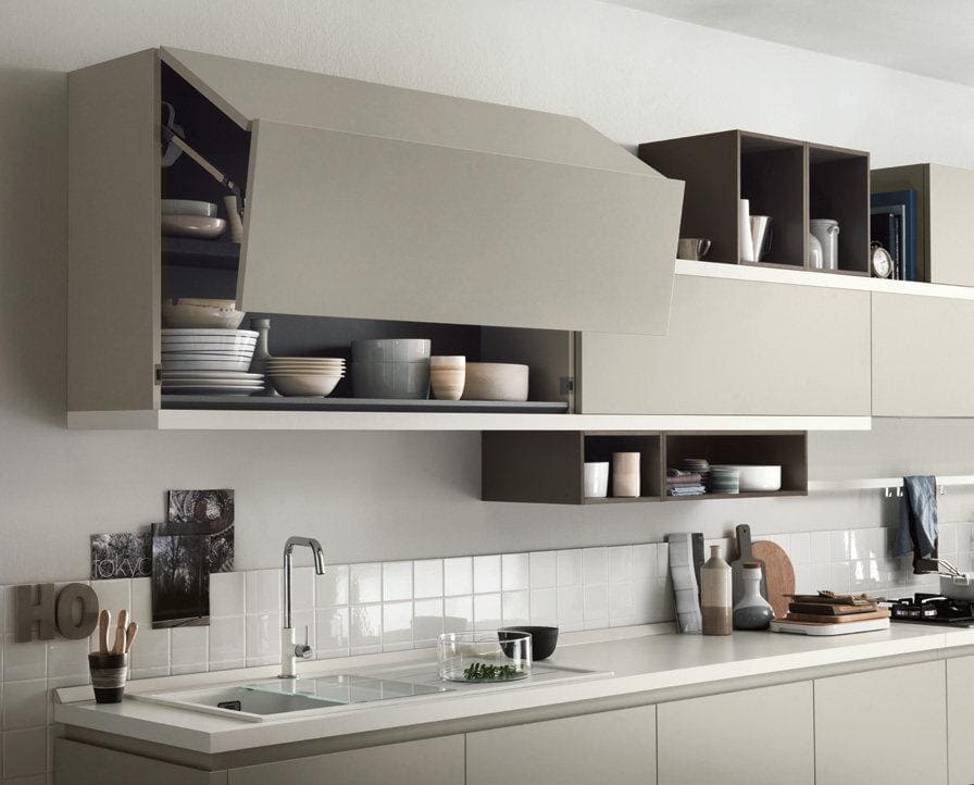 Modern kitchen with beige cabinets, open shelving, dishes, and countertop accessories.