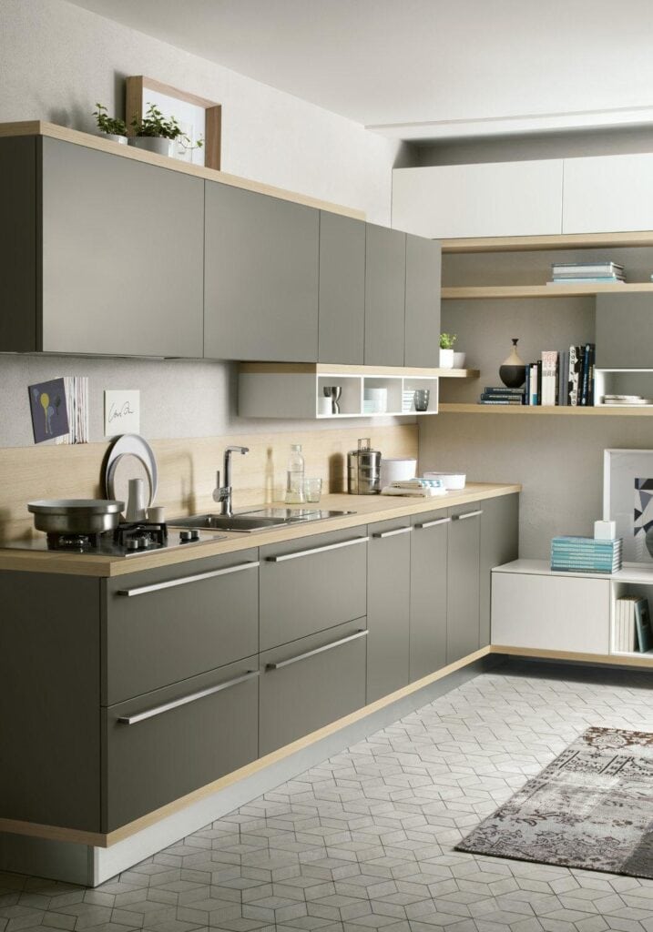 Modern kitchen with gray cabinets, wooden countertops, open shelves, and geometric patterned flooring.
