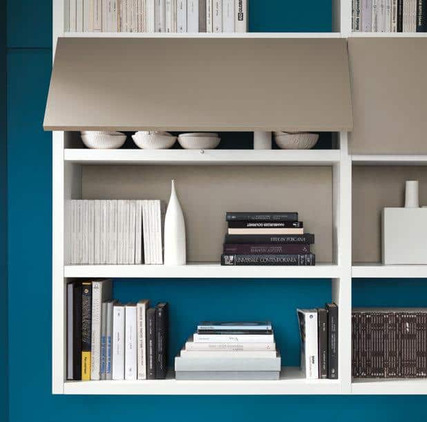 Modern white bookshelf with various books, decorative vases, and three white bowls on a teal and beige background.