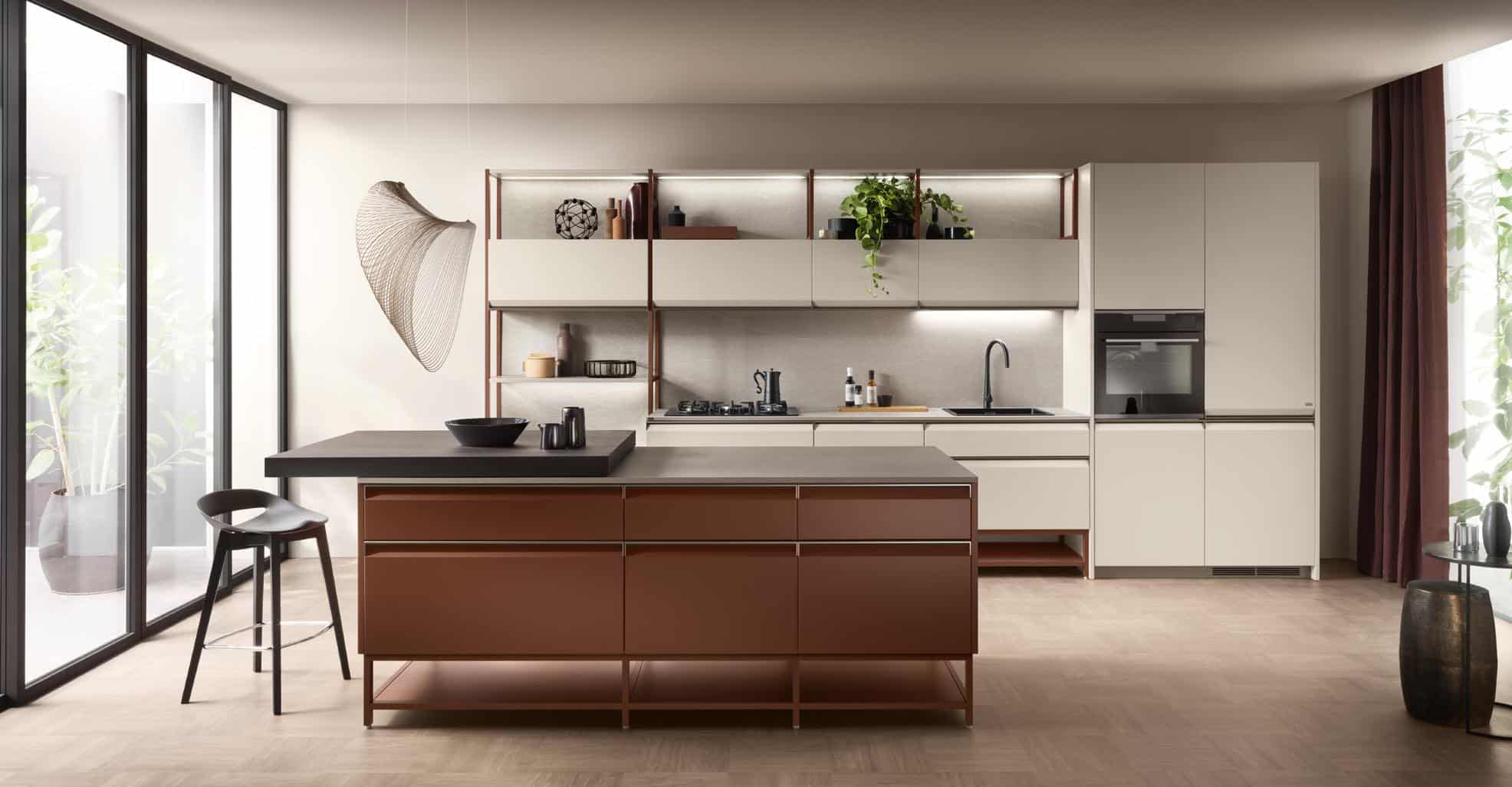 Modern kitchen with a large island, sleek cabinets, an overhead light fixture, and large windows allowing natural light.