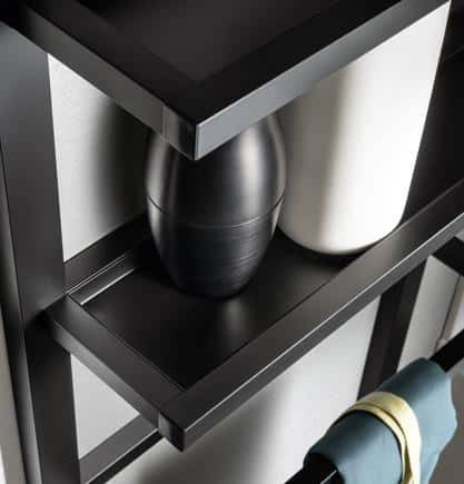 Black metal shelf with two vases and a hanging towel.