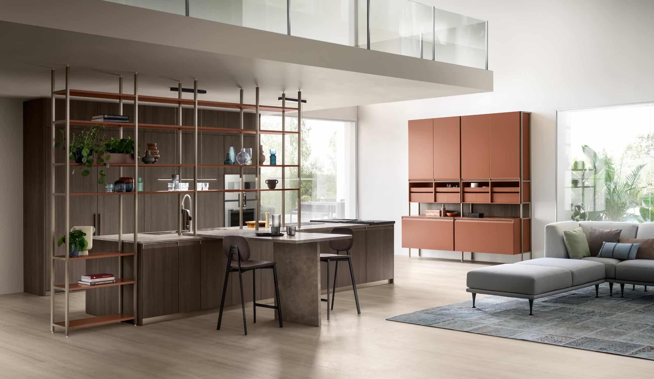 Modern kitchen and living area with open shelving, brown cabinets, a gray sectional sofa, and large windows.