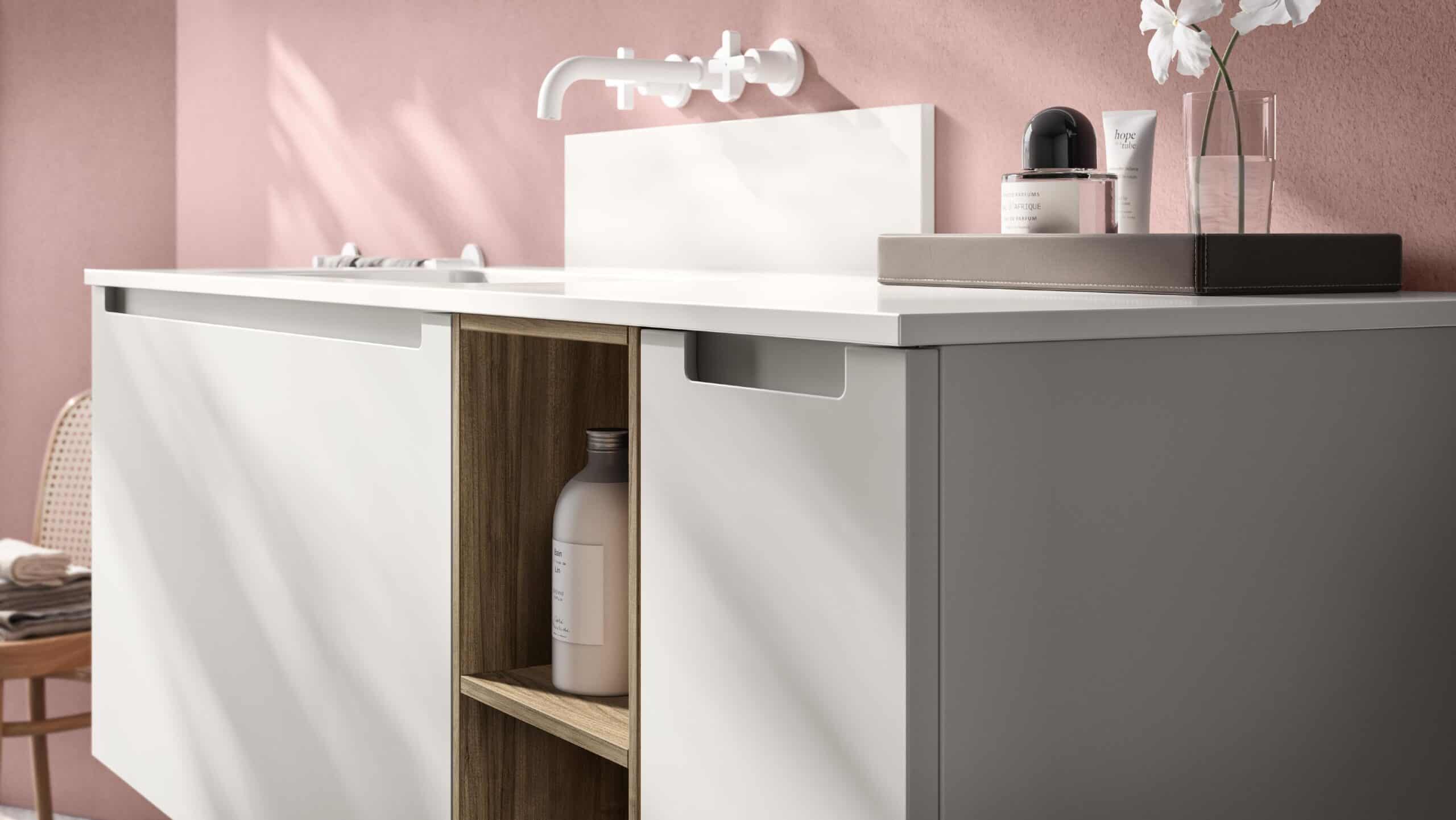 Modern bathroom vanity with a white countertop, minimalist faucet, and open shelving against a pink wall.