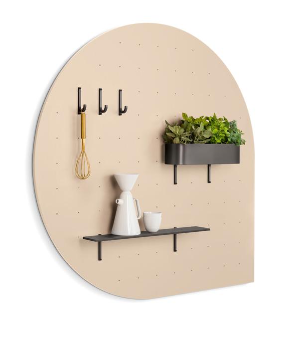 Round pegboard with hooks, shelf, and planter, holding a whisk, a carafe, a mug, and a potted plant.