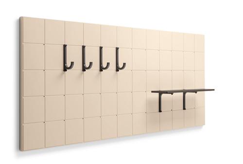 Wall panel with beige tiles featuring five black hooks and a small shelf.