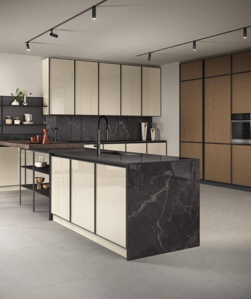 Modern kitchen with beige cabinets, black marble island, wooden panels, and track lighting.